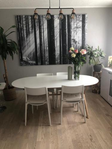 une salle à manger avec une table et des chaises blanches dans l'établissement Une Chambre dans un appartement, à Ablon-sur-Seine
