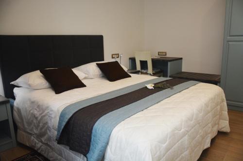 ein großes Bett mit weißer Bettwäsche und schwarzen Kissen in der Unterkunft Villa Almira in Izola