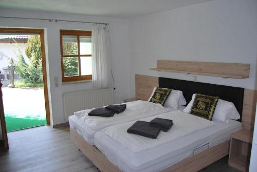 1 dormitorio con 1 cama blanca grande con almohadas negras en PAGA Hotel en Aidenbach