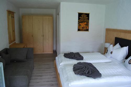 a hotel room with two beds and a couch at PAGA Hotel in Aidenbach