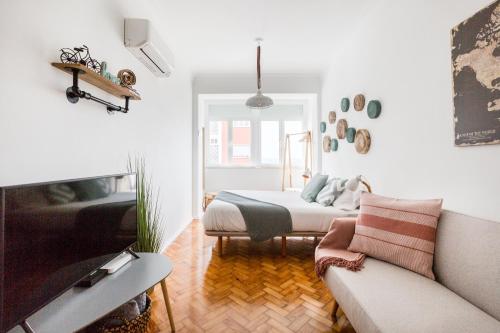 a living room with a bed and a couch at Panoramic River View 1-BR near Senhora do Monte by NestAtLisbon in Lisbon