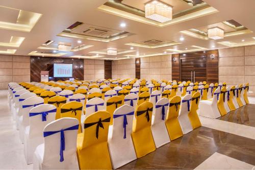 a room with rows of chairs in a hall at Lords Inn Porbandar in Porbandar