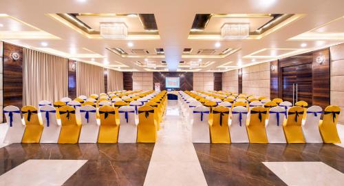 a conference room with yellow and blue chairs in it at Lords Inn Porbandar in Porbandar