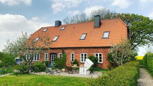 a red brick house with an orange roof at Gutshof Rothensande in Waabs