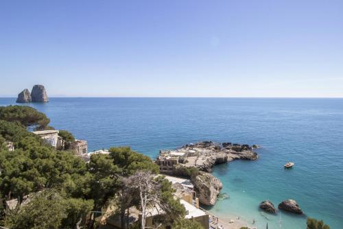 an island in the ocean with boats in the water at La Cuchina in Capri