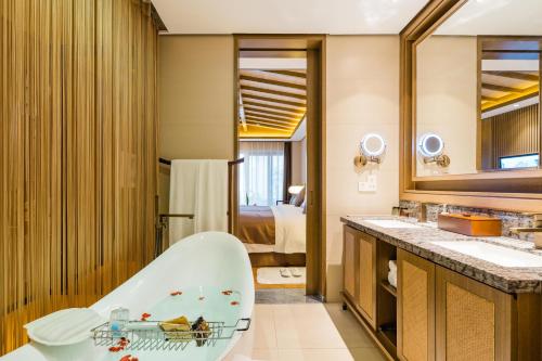 a bathroom with a bath tub and a sink at S&N Zhejiang LinHai International Hotel in Linhai