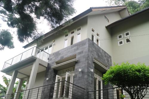 a large white house with a balcony at Villa Babeh in Bandung