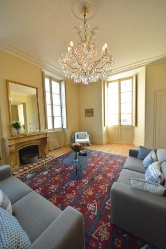 a living room with couches and a chandelier at Les Folies de Chauvin in Bordeaux