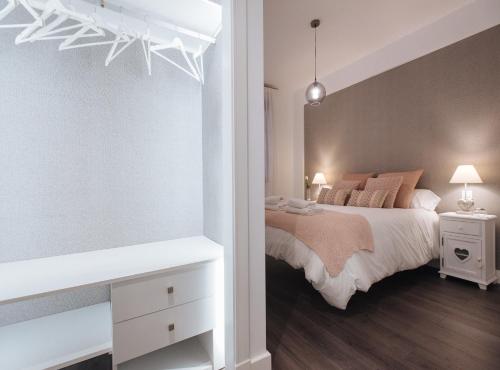 a white bedroom with a bed and a white table at Luxury Apartment in Plaza de Armas in Seville