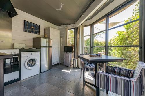 een keuken met een wasmachine en droger en een tafel bij GITE LE RAFLO in Cordemais