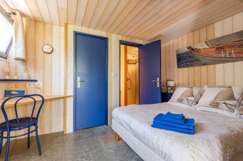 um quarto com uma cama com uma porta azul e uma cadeira em GITE LE RAFLO em Cordemais
