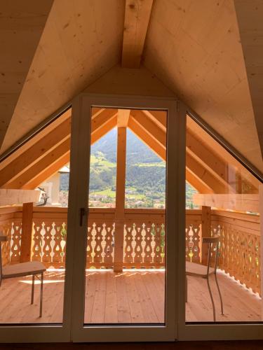 a view from the attic of a house with a glass door at Castell Matscher in Bressanone