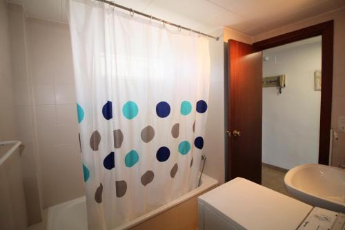 ロザスにあるGlobal Immo 2035 Olympiaのバスルーム(青いドットの白いシャワーカーテン付)