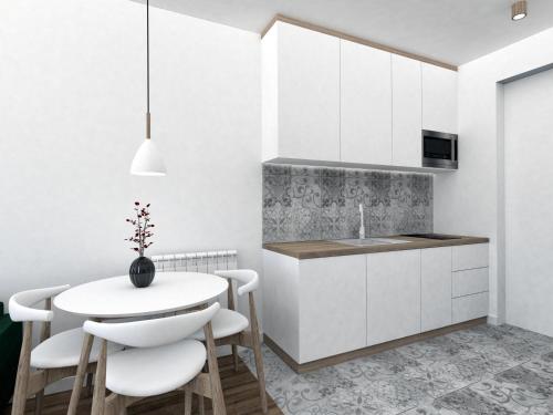una cocina con armarios blancos y una mesa y sillas blancas. en Apartament przy Krupowkach, en Zakopane