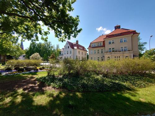 a large building with a red roof in a park at alte Bäckerei Bautzen - 02 #Senior# im Zentrum, mit Parkplatz, Top Ausgestattet in Bautzen