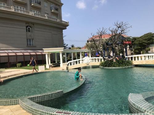 a man is sitting in a pool of water at 84 Trần Phú Căn hộ in Vung Tau