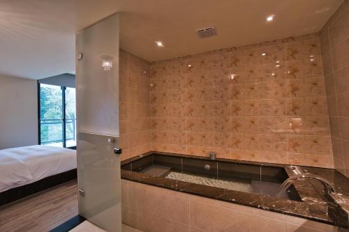 a bathroom with a bathtub in the corner of a room at Taihe sun and the moon hostel in Yuchi