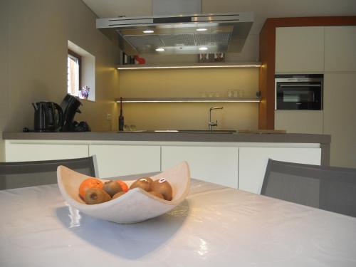 a bowl of fruit sitting on a table in a kitchen at Au Paradis Guesthouse in Waregem