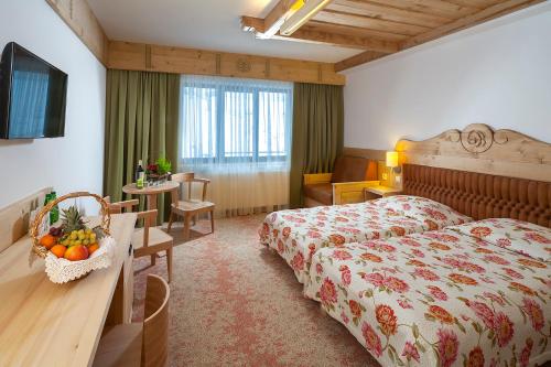 a hotel room with a bed and a table with fruit on it at Hotel Bania Thermal & Ski in Białka Tatrzanska