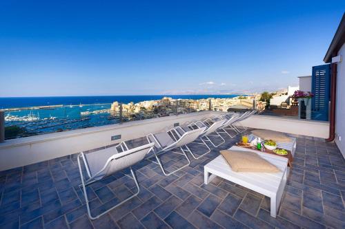 a balcony with chairs and a view of the city at Tannur B&B in Castellammare del Golfo