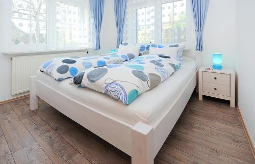 um quarto com uma cama com roupa de cama azul e branca em Jever-Ferienhaus Gartenblick em Jever