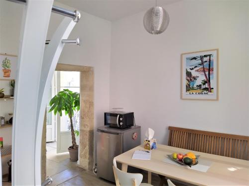 a kitchen with a table and a microwave at le balcon de Saint Roch in Montpellier
