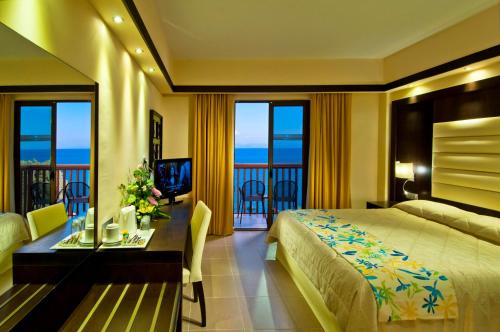 a hotel room with a bed and a table with a tableablish at Oceanis Beach & Spa Resort in Psalidi
