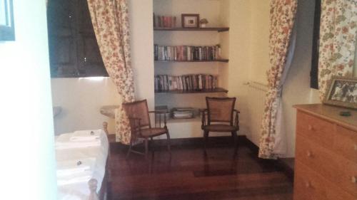 a living room with two chairs and a book shelf at Casa da Arosa in Celorico de Basto