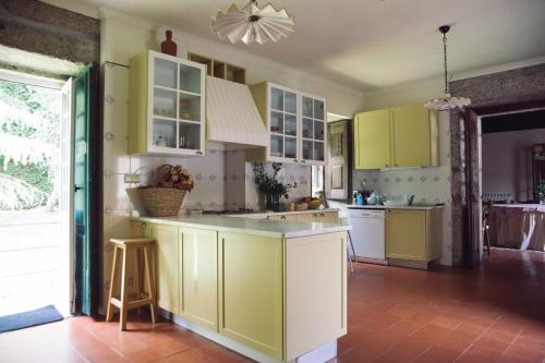 cocina con armarios amarillos y encimera en Casa da Arosa, en Celorico de Basto