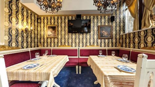 a dining room with two tables and a tv on the wall at Hotel Boyana - Free Parking in Sofia