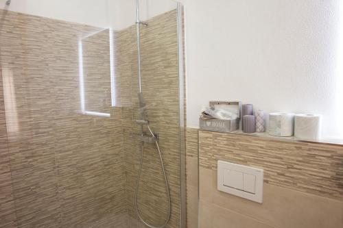 a shower with a glass door in a bathroom at Shardan Guest House in Alghero