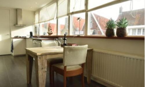 a kitchen with a table and a chair and a window at Cosy Harlingen I in Harlingen