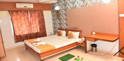 a small bedroom with a bed and a desk at Hotel Mahabir Galaxy in Cuttack