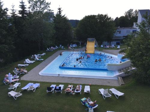 eine Draufsicht auf einen Swimmingpool mit Menschen darin in der Unterkunft Ferienwohnung Reinhold im Predigtstuhl Resort in Sankt Englmar