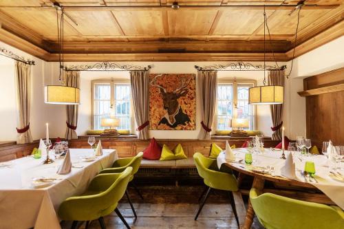 a dining room with tables and chairs and windows at Landgasthof Karner in Frasdorf