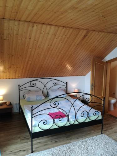 a bed in a room with a wooden ceiling at Vila Štefan Drevko in Poprad