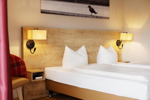 a hotel room with two beds and a bird on the wall at Hotel Ahornhof in Lindberg