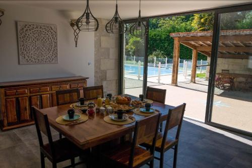 ChaniersにあるLes Cuves - Saintesのダイニングルーム(木製テーブル、大きな窓付)