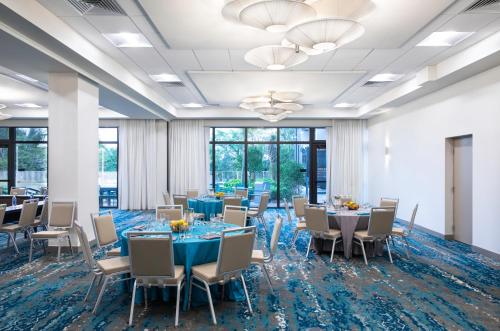 a conference room with tables and chairs and windows at EVEN Hotel Miami - Airport by IHG in Miami