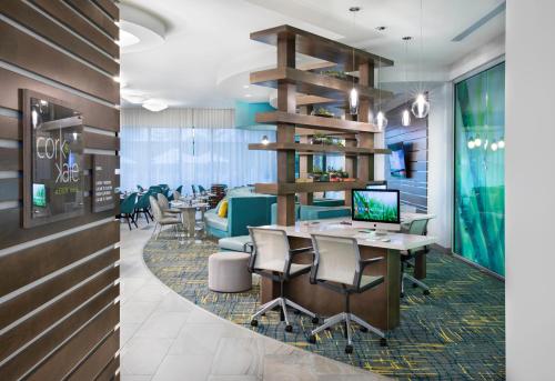 a restaurant with a table with chairs and a laptop at EVEN Hotel Miami - Airport by IHG in Miami