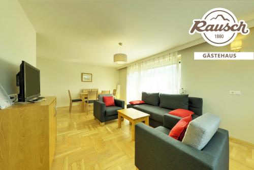 a living room with a couch and a tv at Alpen Adria Gasthof Rausch in Ledenitzen