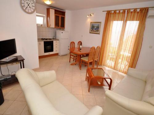 a living room with a white couch and a table at Apartments Seagull in Postira