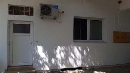 a white wall with a door and a fan at Apartment Eurho in Osijek