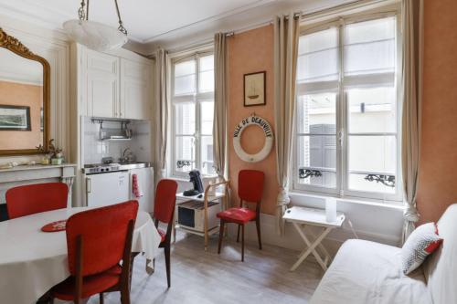 une cuisine et un salon avec une table et des chaises dans l'établissement Appartement des Embruns - Welkeys, à Trouville-sur-Mer