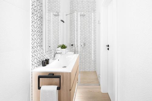 une salle de bains avec un lavabo blanc et un miroir dans l'établissement Brill Budapest Apartments 6, à Budapest