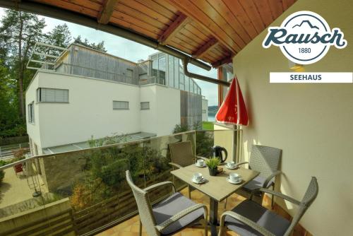 a balcony with a table and chairs and a building at Seehaus Rausch in Egg am Faaker See