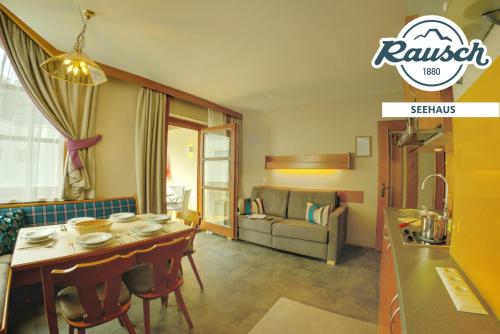 a kitchen and living room with a table and a couch at Seehaus Rausch in Egg am Faaker See