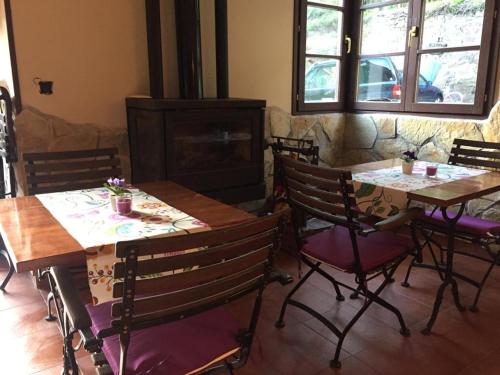 ein Esszimmer mit 2 Tischen und Stühlen sowie einem Kamin in der Unterkunft Hotel peñacabrera 1 in Santa Eulalia