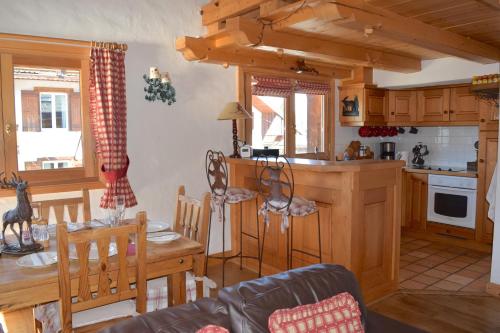 a kitchen and living room with a table and chairs at Chalet Roseau in Megève