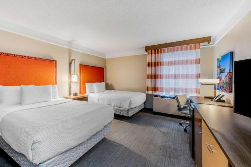 a hotel room with two beds and a flat screen tv at La Quinta by Wyndham New Orleans Downtown in New Orleans